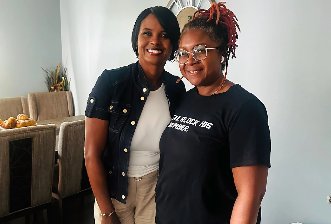 Two women standing next to each other in a room.